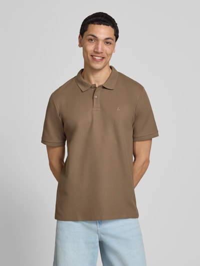 Męski model nosi koszulkę polo Regular Fit Poloshirt mit Strukturmuster Modell 'AUSTIN' von Jack & Jones, mieszanka bawełny, fakturowany wzór, haft, listwa guzikowa, kolor beżowy, krój regular fit, długość tyłu w rozmiarze M: 69 cm, widok całej sylwetki z przodu.