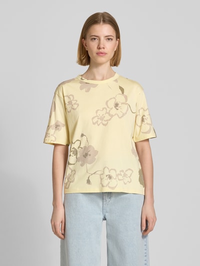 Modelka nosi T-Shirt im Allover-Look mit Rundhalsausschnitt von JAKE*S STUDIO WOMAN, bawełna, krój regular fit, żółty z kwiatowym wzorem, widok całej sylwetki z przodu.