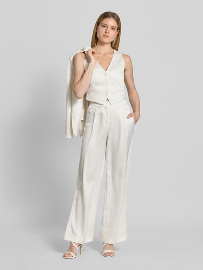 Modelka nosi Hose mit weitem Bein und Falten von Jake*s Cocktail, satynowa, szerokie nogawki, fałdy, kieszeń z tyłu, szerokość w rozmiarze 36: 34 cm, długość nogawki od wewnątrz w rozmiarze 36: 82 cm, kremowa, gładka faktura, pełny widok z przodu