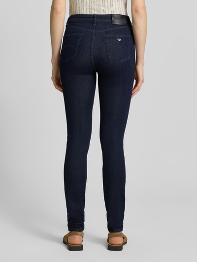 Frauenmodel trägt Slim Fit Jeans aus Viskose-Mix im 5-Pocket-Design von Emporio Armani in Dunkelblau, elastischer Stoff, Ganzkörperansicht Rückansicht.