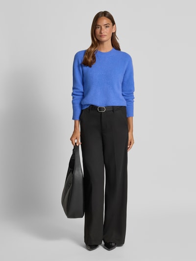Frauenmodel trägt Strickpullover mit Rundhalsausschnitt von Oui in Blau, Regular Fit, weiche Textur, kombiniert mit schwarzer Hose, Ganzkörperansicht von vorne.