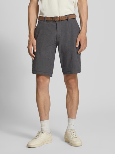 Männermodel trägt Bermudas mit Gürtel und Eingrifftaschen Modell 'NEBRASKA' von Redefined Rebel aus Baumwoll-Mix mit Stretch-Anteil, Ganzkörperansicht von vorne.