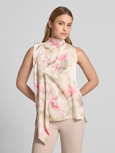 Modelka kobieca nosi Bluse mit Stehkragen und asymmetrischem Design od Rinascimento, pastelowe beżowe i różowe odcienie, materiał elastyczny, prosty krój, asymetryczne marszczenia, stójka, kluczowy dekolt z tyłu, długość tyłu w rozmiarze S: 67 cm, zdjęcie całej sylwetki z przodu.