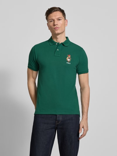Męskijmodel nosi Regular Fit Poloshirt aus reiner Baumwolle von Polo Ralph Lauren, efekt: jednolity kolor, krój regular fit, wyhaftowane logo i motyw, kołnierzyk polo, dekolt w serek, krótkie zapięcie na guziki, krótki rękaw, prążkowane zakończenie rękawów, wykończenie z bocznymi rozcięciami, asymetryczny dół, wykończenie materiału: pika, materiał: bawełna, całkowity przód.