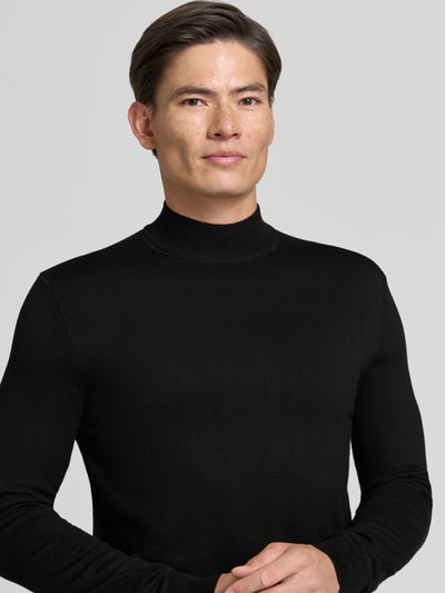 Mannelijk model draagt Rollkragenpullover met Viskose-Anteil van MARKUP in zwart met ribboorden, recht model, ruglengte maat M 67 cm, mouwlengte maat M 49 cm, nahaufnahme bovenlichaam.