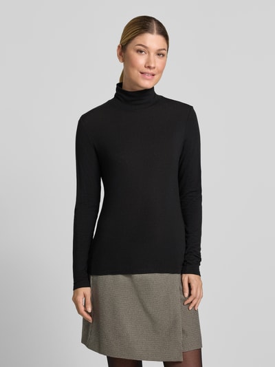 Frauenmodel trägt Longsleeve aus Lyocell-Mix mit Stehkragen von windsor., schwarz, schmal geschnitten, zu Rock kombiniert, Ganzkörperansicht von vorne. Rückenlänge bei Größe 36: 56 cm.