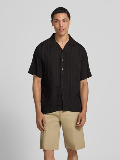Männermodel trägt Modern Fit vrijetijdsoverhemd met structuurpatroon model 'Henrik' van Redefined Rebel in zwart, rayonmix, reverskraag, knoopsluiting. Ganzkörperansicht van voren. Context: heren vrijetijdsoverhemd met ruglengte maat M 72 cm, schouderbreedte 51 cm, mouwlengte 27 cm.