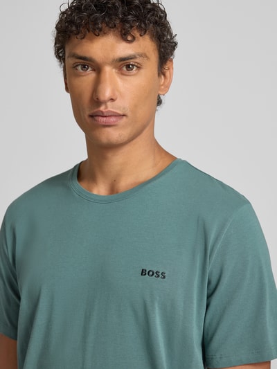 Männermodel trägt Regular Fit T-Shirt aus Baumwoll-Mix Modell 'MIX&MATCH T-SHIRT R' von BOSS in Optik: Unifarben, Label-Stitching-Applikation, Kontraststreifen am Rundhals, Kurzarm, Nahaufnahme Oberkörper.