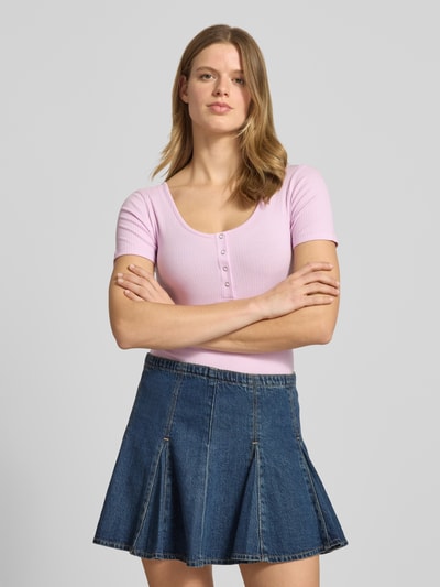 Frauenmodel trägt Slim Fit T-Shirt aus Baumwoll-Mix Modell 'KITTE' von Pieces in Rosa, Rippstruktur, U-Boot-Ausschnitt, Nahaufnahme Oberkörper.