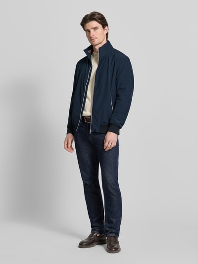 Männermodel trägt Jacke mit Stehkragen von Christian Berg Men in Dunkelblau, lockerer Schnitt, Reißverschluss, Ganzkörperansicht von vorne.