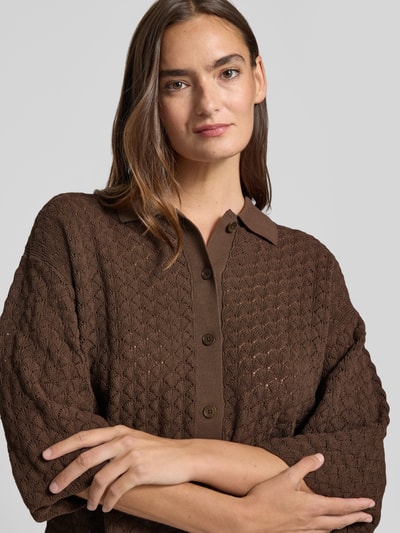 Vrouwenmodel draagt gebreid shirt van puur katoen, boxy fit, polokraag, knoopsluiting, 3/4-mouw, model 'LOYSIA' van DRYKORN, close-up bovenlichaam.