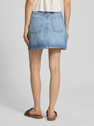 Frauenmodel trägt eng anliegenden Jeansrock aus Bio-Baumwoll-Mix Modell 'STELLA' von Only in Denim-Optik, Mini-Länge, 5-Pocket-Design, Ganzkörperansicht Rückansicht.