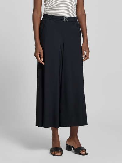 Frauenmodel trägt Hose in verkürzter Passform mit Gürtel Modell 'Pia' von MAC, schwarz, weites Bein, elastischer Bund, Material-Mix, Nahaufnahme Oberkörper.