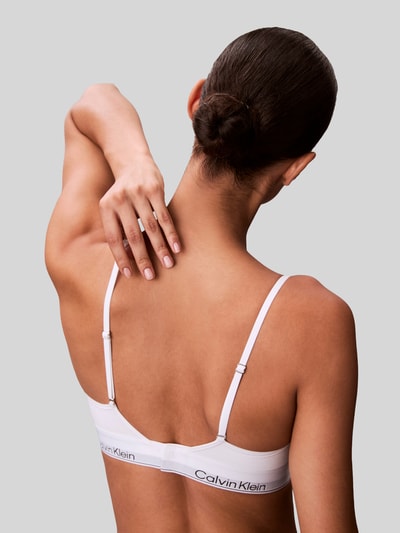 Frauenmodel trägt Balconette BH mit Logo-Stitching von Calvin Klein Underwear aus elastischem Baumwoll-Mix mit Modal-Anteil, Verstellbare Träger, Haken-Verschluss, Ganzkörperansicht Rückansicht.