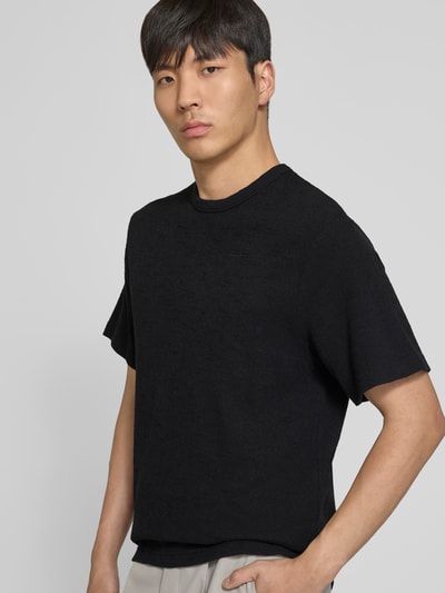 Männermodel trägt Relaxed Fit T-Shirt mit Strukturmuster von Forét, Reine Baumwolle, Logo-Stitching, Rundhalsausschnitt, Rückenlänge bei Größe M 69 cm, Ganzkörperansicht von vorne.