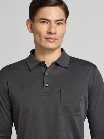 Männermodel trägt Poloshirt mit Brusttasche von Lerros in Dunkelgrau aus Baumwoll-Mix, Regular-Fit, Nahaufnahme Oberkörper.