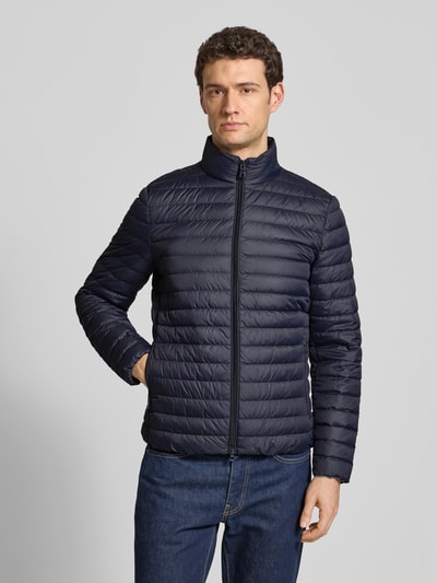 Mannenmodel draagt Steppjacke mit Stehkragen und Zweiwege-Reißverschluss van Geox in donkerblauw, regular fit, met ritszakken, volledig vooraanzicht.