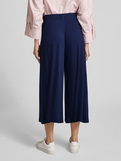 Frauenmodel trägt Loose Fit Culotte aus Viskose-Mix von Armedangels in Dunkelblau, elastischer Bund, Jersey, unifarben, Ganzkörperansicht Rückansicht.