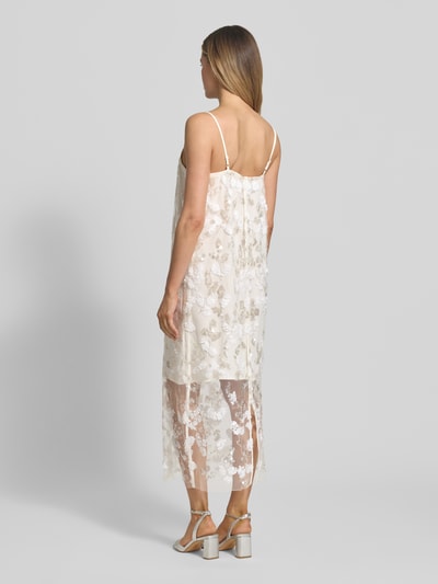 Frauenmodel trägt Midikleid mit Pailletten Modell 'ZIA' von Copenhagen Muse in Creme mit geradem Schnitt und Gehschlitz, Rückansicht Ganzkörperansicht.