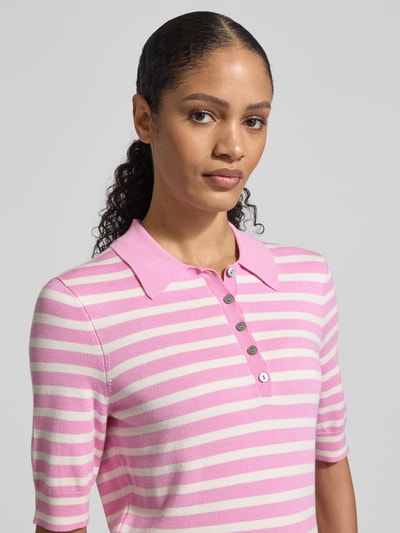 Frauenmodel trägt Poloshirt aus Viskose-Mix von Christian Berg Woman, rosa-weiß gestreift, Polokragen, 1/2-Arm, Nahaufnahme Oberkörper.