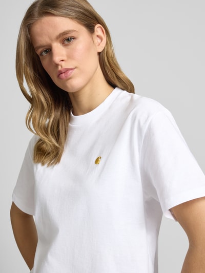 Frauenmodel trägt Damen T-Shirt mit Label-Stitching von Carhartt Work In Progress, weiße Bio-Baumwolle, Relaxed-Fit, Rundhalsausschnitt, Nahaufnahme Oberkörper. Rückenlänge Größe S: 64 cm.