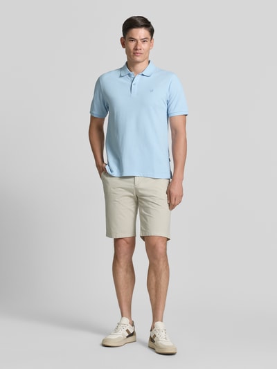 Męski model nosi Slim Fit Poloshirt mit Stitching von Jack & Jones Premium, jasnoniebieska bawełna, krój slim fit, detaliczna faktura, widok całej sylwetki z przodu.