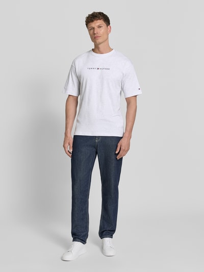 Männermodel trägt Regular Fit T-Shirt aus reiner Baumwolle von Tommy Hilfiger, Optik: Unifarben, Label-Print, Jersey, Ganzkörperansicht von vorne.