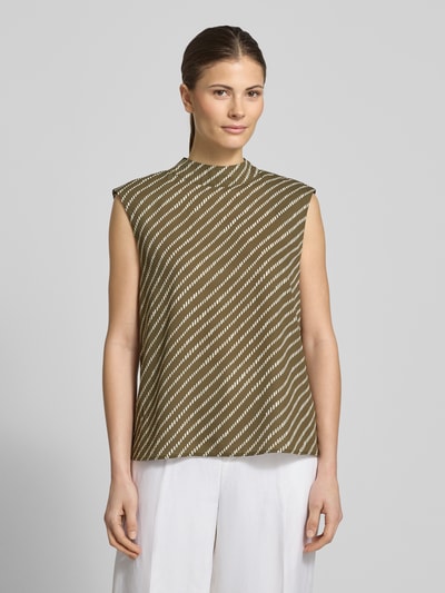 Kobiece modelka nosi Regular Fit Top mit Stehkragen od comma, krój regular fit, zapięcie na haftkę, krój bez rękawów, długość tyłu w rozmiarze 36: 57 cm, oliwkowe tło z białym geometrycznym wzorem; widok całej sylwetki z przodu.