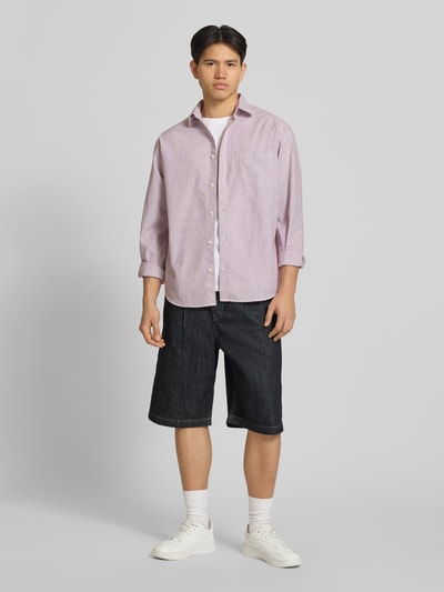 Mężczyzna model nosi bermudy Extra Baggy Fit model LLOYD od Jack & Jones, wykonane z bawełny, wpuszczane kieszenie, szerokość w rozmiarze M: 41 cm, długość wewnętrzna nogawki w rozmiarze M: 30 cm, widok całej sylwetki z przodu.