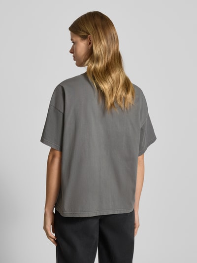 Kobiece model prezentuje Oversized T-Shirt mit Label-Stitching od Pegador z bawełny, prążkowany okrągły dekolt, stonowany kolor, długość tyłu 60 cm przy rozmiarze S, krój oversized, Ganzkörperansicht Rückansicht.