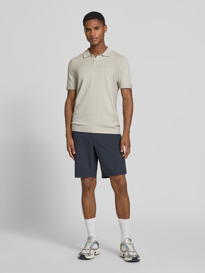 Männermodel trägt Poloshirt mit Logo Detail von BOSS Green, Optik: Unifarben, Passform: Regular-Fit, Logo-Print, Polokragen, Bodymapping-Struktur, Ganzkörperansicht von vorne.