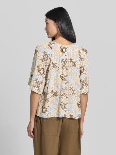 Frauenmodel trägt Relaxed Fit Kurzarmbluse aus Viskose-Mix von s.Oliver RED LABEL in Beige, Hellblau und Braun, florales Muster, lockere Struktur, Ganzkörperansicht Rückansicht. Damen Kurzarmbluse von s.Oliver RED LABEL.