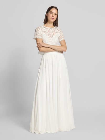 Kobiece modelka nosi Maxirock aus Chiffon mit Reißverschluss od Luxuar, biały, lekko rozkloszowany, zwiewny materiał, Szerokość w rozmiarze 36: 34 cm, długość całkowita: 125 cm, zdjęcie całej sylwetki z przodu.