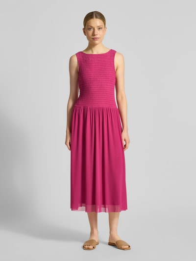 Frauenmodel trägt Midikleid aus Mesh mit Smok-Details von Christian Berg Woman Selection in gerade geschnittener, pinker Optik, Ganzkörperansicht von vorne.