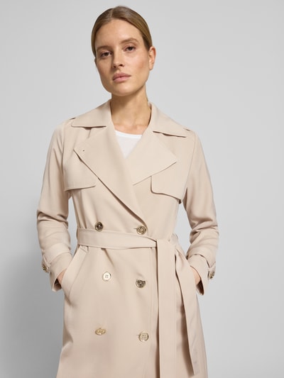 Vrouwenmodel draagt Zweireihiger Trenchcoat mit Bindegürtel van MICHAEL Michael Kors in beige met reverskraag, regular fit, met dubbele rij knopen, strikceintuur, gladde textuur, borstwijdte 50 cm, schouderbreedte 40 cm, mouwlengte 63 cm, ruglengte 47 cm, nahaufnahme bovenlichaam.