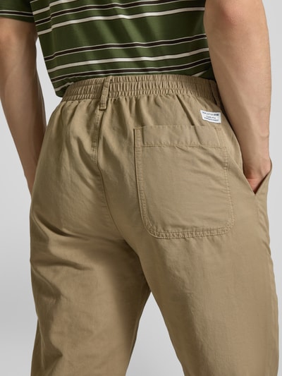 Męski model nosi Relaxed Fit Chino aus Baumwolle-Leinen-Mix Modell 'FILIP RELAXED' od Marc O'Polo Denim, jednolity beż, guzik, zamek, elastyczny pas, bawełna-len, wszyta tylna kieszeń, label patch, spodnie z paskiem; detaliczne ujęcie tylnej części.