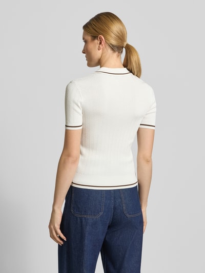 Modelka kobieta ma na sobie Strickshirt aus Viskose-Mix mit Polokragen und V-Ausschnitt od ARMANI EXCHANGE, biały, krój slim fit, tył, widok całej sylwetki