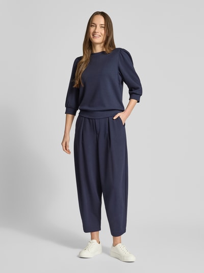 Frauenmodel trägt Sweatpants mit elastischem Bund von Rich & Royal im Dunkelblau, Modal-Mix mit Stretch-Anteil, lockerer Schnitt, französische Eingrifftaschen, Gesäßtaschen, Innenbeinlänge 64 cm bei Größe S, Ganzkörperansicht von vorne.