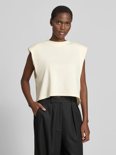 Frauenmodel trägt Top mit Rundhalsausschnitt von black palms in Creme, Reine Baumwolle, Relaxed-Fit, Schulterpolster, Ärmelloses-Design, Rückenlänge 48 cm bei Größe S, Nahaufnahme Oberkörper.