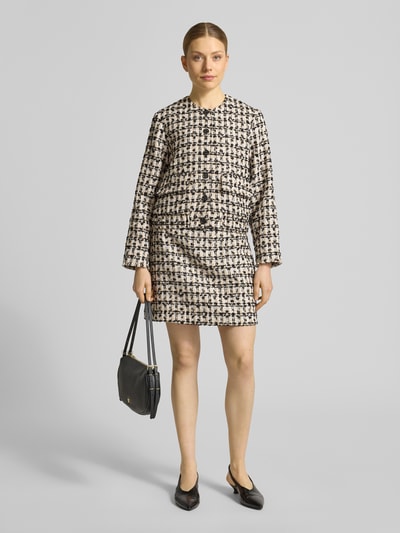 Frauenmodel trägt Regular Fit Blazer in Bouclé-Optik Modell 'Jenifer' von JOOP! mit AufgesetzteTaschen, Knopfleiste, Rundhalsausschnitt, Farbspiel aus Schwarz und Creme, strukturierte Oberfläche, Ganzkörperansicht von vorne.