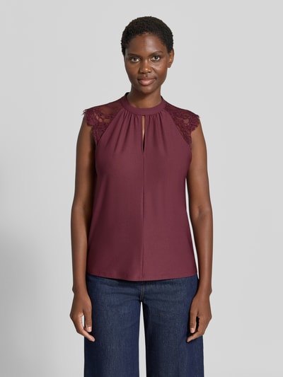Frauenmodel trägt Regular Fit Kurzarmbluse mit semitransparenter Besatz Modell 'MILLA' von VERO MODA in Dunkelrot, glatte Textur, Spitzenapplikationen an den Schultern, Ganzkörperansicht von vorne, Damen Kurzarmbluse von VERO MODA.