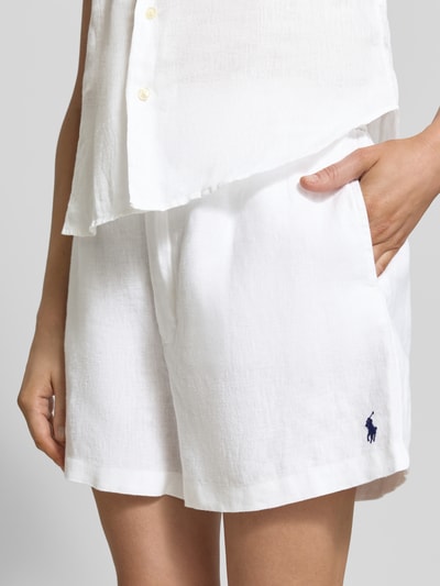 Vrouwenmodel draagt Regular Fit Leinenshorts met Tunnelzug van Polo Ralph Lauren, wit linnen, effen, logo-stitching, tailleband met trekkoord, zij- en achterzakken, detailopname heup.