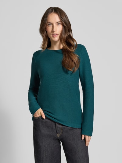 Frauenmodel trägt Regular Fit Strickpullover aus reiner Baumwolle von Tom Tailor, unifarben in Dunkelgrün, Rippstrick, Ganzkörperansicht von vorne.
