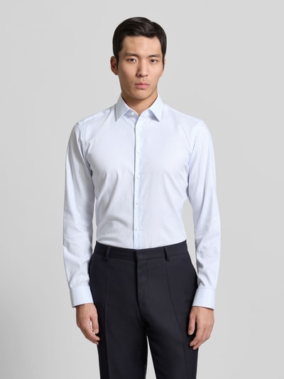 Męski model nosi Regular Fit Business Hemd aus Baumwolle mit Kentkragen von Jake*s, białe z delikatnymi paskami, krój regular fit, bawełna, guziki, długość tyłu w rozmiarze 39/40: 78 cm, szerokość w rozmiarze 39/40: 47 cm, długość rękawa w rozmiarze 39/40: 65 cm, widok całej sylwetki z przodu.