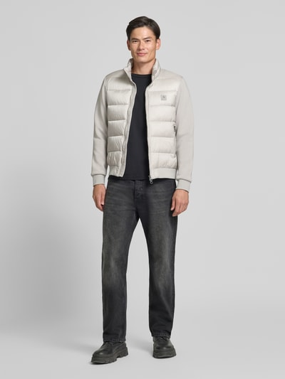 Mannenmodel draagt Jacke met Label-Patch en opstaande kraag van Antony Morato in lichtgrijs, slim fit, tweewegritssluiting, labelpatch, zij-ritszakken, elastische boorden, ruglengte maat 50: 67 cm, schouderbreedte: 48 cm, borstwijdte: 56 cm, mouwlengte: 67 cm, volledige lichaamsaanzicht van voren.