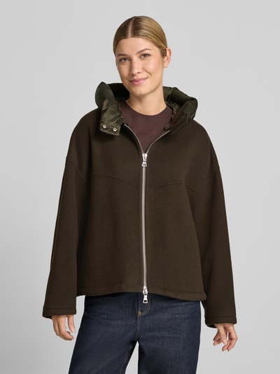 Frauenmodel trägt Doubleface Wolljacke mit abnehmbarer Steppkapuze von Blonde No. 8 in Dunkelbraun, Relaxed Fit, Zweiwege-Reißverschluss, elastische Ärmelabschlüsse, Ganzkörperansicht von vorne.