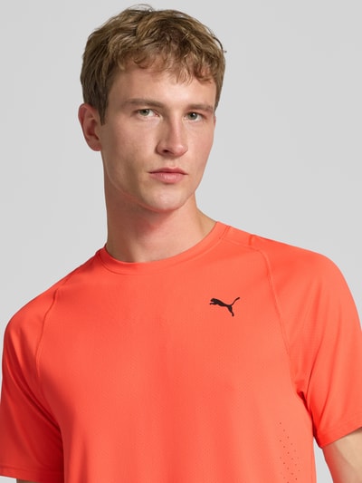 Männermodel trägt oranges Regular Fit Sport-T-Shirt mit Logo-Print Modell 'M PWRMODE' von PUMA, Herren Sport-T-Shirt, Nahaufnahme Oberkörper