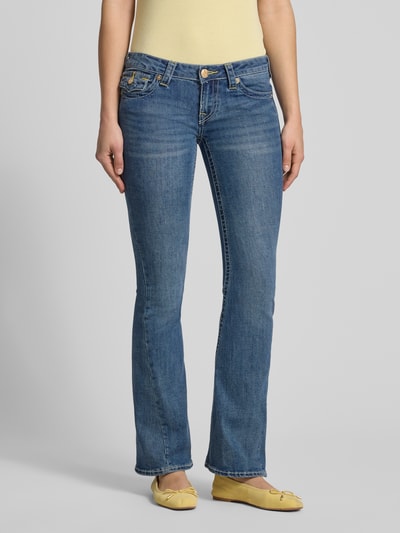 Frauenmodel trägt Low Rise Flared Jeans im 5-Pocket-Design Modell 'JOEY' von TRUE RELIGION, blauer Baumwoll-Mix, Ganzkörperansicht von vorne.