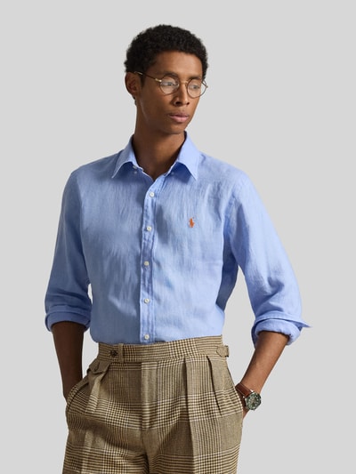 Mannenmodel draagt Regular Fit Freizeithemd aus reinem Leinen van Polo Ralph Lauren in lichtblauw, unie kleur, flammétextuur, lange mouwen, borstlogo, knoopsluiting, recht model, geheel aanzicht van voren.