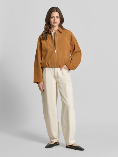 Frauenmodel trägt Bomberjacke aus Velours mit Eingrifftaschen von Jake*s Collection in Braun, Umlegekragen, Relaxed Fit, Ganzkörperansicht von vorne.